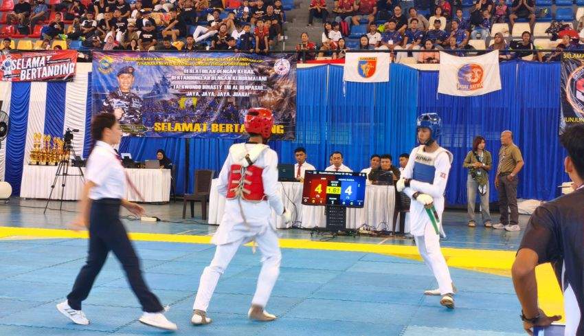 Suasana pertandingan Singaraja Open Taekwondo Championship 2026 di GOR Fakultas Olahraga dan Kesehatan Undiksha Singaraja dengan atlet yang sedang bertanding di atas matras.