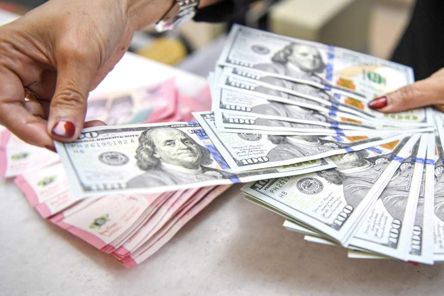 Karyawan menghitung uang pecahan rupiah dan dolar Amerika Serikat di gerai penukaran mata uang asing Ayu Masagung, Jakarta.
